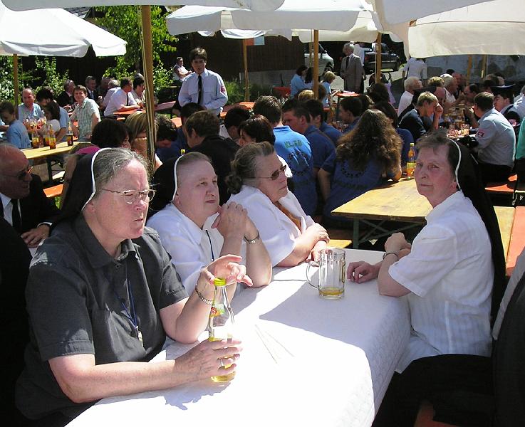 Schwestern.JPG - Die Ehrwürdigen Schwestern (mit der früheren Pfarrhaushälterin) lauschen den Grußworten am Frühschoppen im Hof des Pfarrheims.